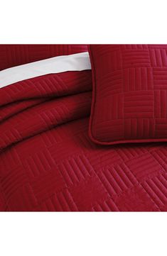 a red comforter with white trim on it