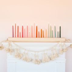 there are many candles on the mantle with tassels