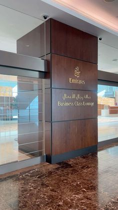 the entrance to emirates business class lounge at london's heath airport, with marble flooring