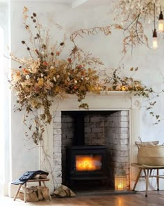 the fireplace is decorated with dried flowers and candles