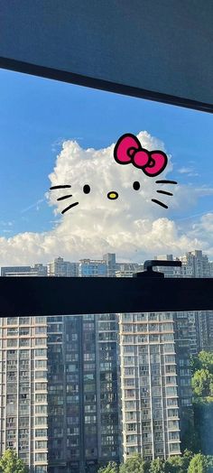 a window with a hello kitty sticker on it's side in front of a cityscape