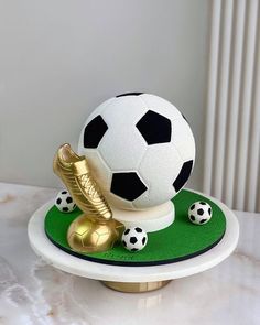 a cake with a soccer ball on top of it and some gold balls around the base