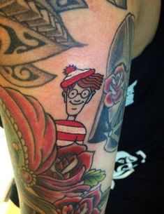 a man with a tattoo on his arm holding a surfboard and wearing a red hat