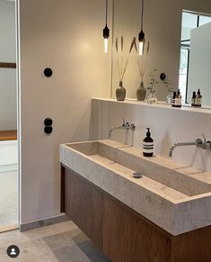 a bathroom with two sinks and mirrors in the wall, along with an open door leading to another room