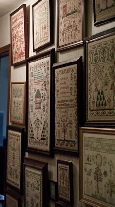 many framed cross - stitchs are hung on the wall