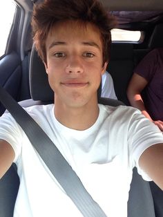 a young man sitting in the back seat of a car