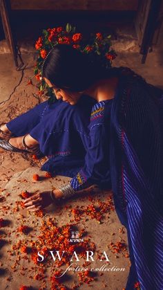 a woman is sitting on the ground with flowers all over her body and shoes in hand