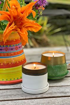 a white and bronze ceramic candle with a brass and green candle next to a vase with flowers on a wooden table Creative Candles, Unique Housewarming Gifts, Unique Candles, Housewarming Gifts, Women Artisans, Handmade Candles, Gift Sets