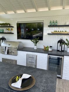 an outdoor kitchen with stainless steel appliances and counter tops