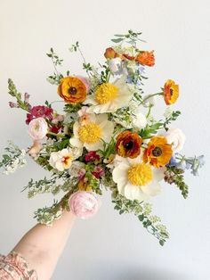 a person holding a bouquet of flowers in their hand