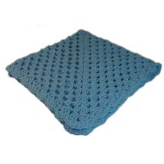 a blue crocheted blanket sitting on top of a white surface