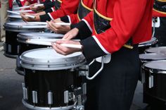 drummers in uniform playing drums on the street