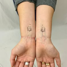 two people with matching tattoos on their hands