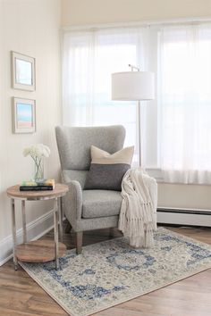 a living room with a chair, lamp and rug