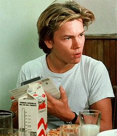 a man sitting at a table with food and milk