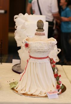 there is a cake that looks like a dress on top of a table with people in the background