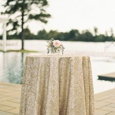 an image of a table set up with flowers on it for a wedding reception in front of the water