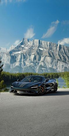 a black sports car parked in front of a mountain