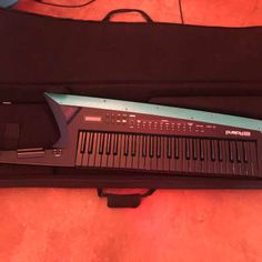 an electronic keyboard in a case on the floor