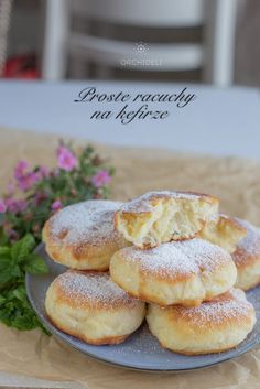 powdered sugar filled biscuits on a plate with flowers in the background and words above it