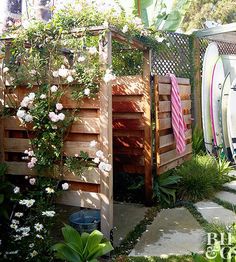 a wooden fence with flowers and surfboards on it