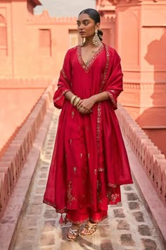 Red kurta featuring floral patra embroidery and a V neck design. Paired with a pant that has a patra embroidered hem and a floral embroidered border dupatta., Fit: Relaxed Affordable Zari Work Kurta For Diwali, Cheap Zari Work Kurta For Diwali, Luxury Katan Silk Kurta For Navratri, Luxury Slub Silk Kurta For Navratri, Luxury Red Kurta With Cutdana Details, Luxury Cotton Traditional Wear With Gota Work, Luxury Red Salwar Kameez Straight Kurta, Luxury Red Chanderi Kurta, Luxury Dola Silk Kurta For Navratri