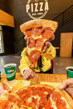 a girl eating a slice of pepperoni pizza