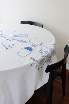 a white table with blue writing on it and a black chair in front of it