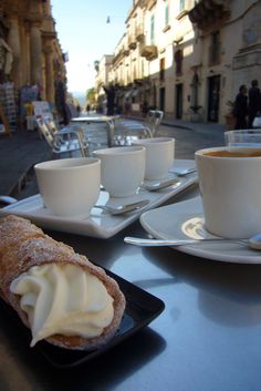 two cups of coffee and some pastries on a table