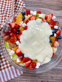 a bowl filled with fruit and yogurt on top of a wooden table