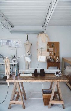 a workbench with mannequins on it in a room filled with furniture