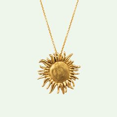 a gold sunflower pendant on a chain