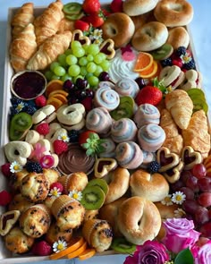 a tray filled with lots of different types of pastries and fruit on top of it