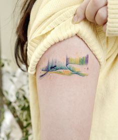 a woman with a tattoo on her arm that has an image of the aurora bore