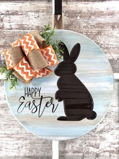 a wooden plate with a black bunny on it and a happy easter sign in the center