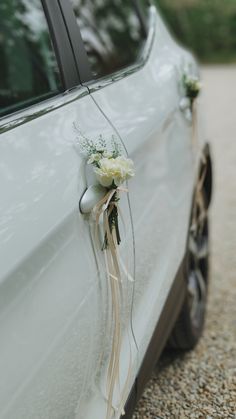 a wedding car decorated with flowers and ribbons