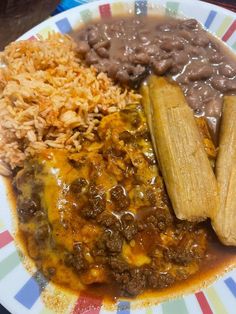 a plate with beans, rice and corn on it