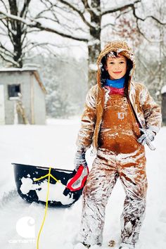 Boy standing outside, covered in snow, with his sled behind him. Gifts For Kids, For Kids, Gifts