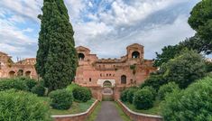 the entrance to an old castle surrounded by trees