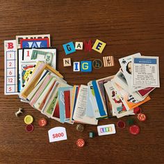 a wooden table topped with lots of different types of cards and magnets on top of it