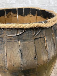 an old wooden basket with rope on top