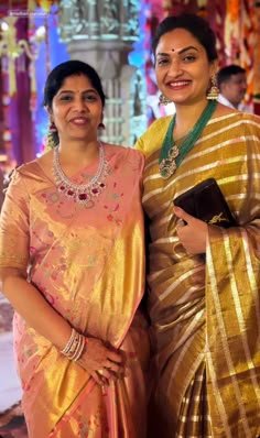 two women standing next to each other in sari