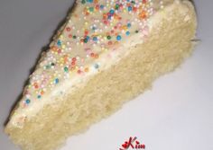 a piece of cake with white frosting and sprinkles