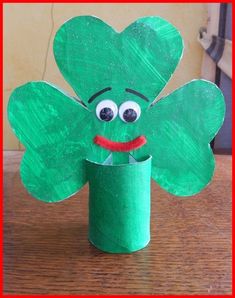 a paper cup with a green leaf shaped like a clover on it's face