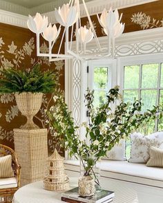 a living room filled with furniture and a chandelier hanging from the ceiling next to a window