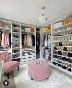 a walk in closet with white shelving and pink ottoman