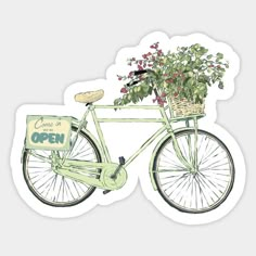 a green bicycle with a basket full of flowers on the front and side, sitting next to a sign that says come in open