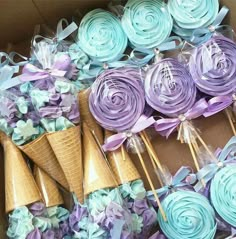 an ice cream cone filled with cupcakes and paper flowers in a cardboard box