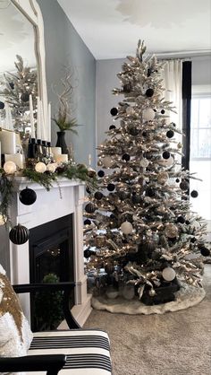 a living room with a christmas tree in the corner and other decorations on the fireplace mantel