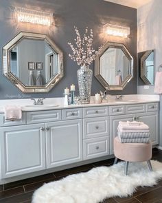 a bathroom with two sinks and three mirrors on the wall next to each other,